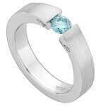 A white gold ring with a blue topaz stone, tension-set and identified as Tension Set Round Blue Diamond Ring C936.