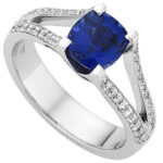 A Split Band With Ceylon Sapphire Ring C1200 featuring a mesmerizing Ceylon Sapphire set amongst sparkling diamonds, all encased in lustrous white gold.