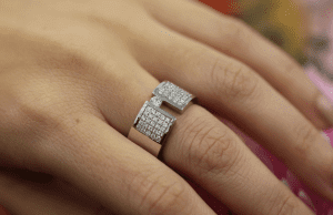A Wide Tension Set Diamond Ring With Diamond Band C809 adorns a woman's hand.