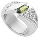 A white gold handmade tension set ring showcases a green sapphire set in the center with one side adorned with pave diamonds, reminiscent of the Tension Set Sapphire & Diamond Ring - 1998 Jewellery design Award Finalist