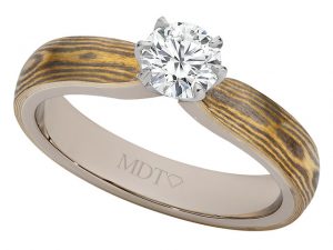 A 6 Claw Diamond Mokume Gane engagement ring featuring a diamond at its center.
