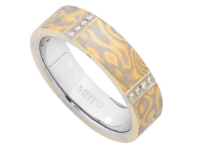 A Mokume Gane ring with grain set white diamonds in yellow gold and white gold.