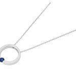 A Tension Set Blue Sapphire Necklace C1061, featuring a silver circle pendant adorned with a captivating blue sapphire stone (C1061).