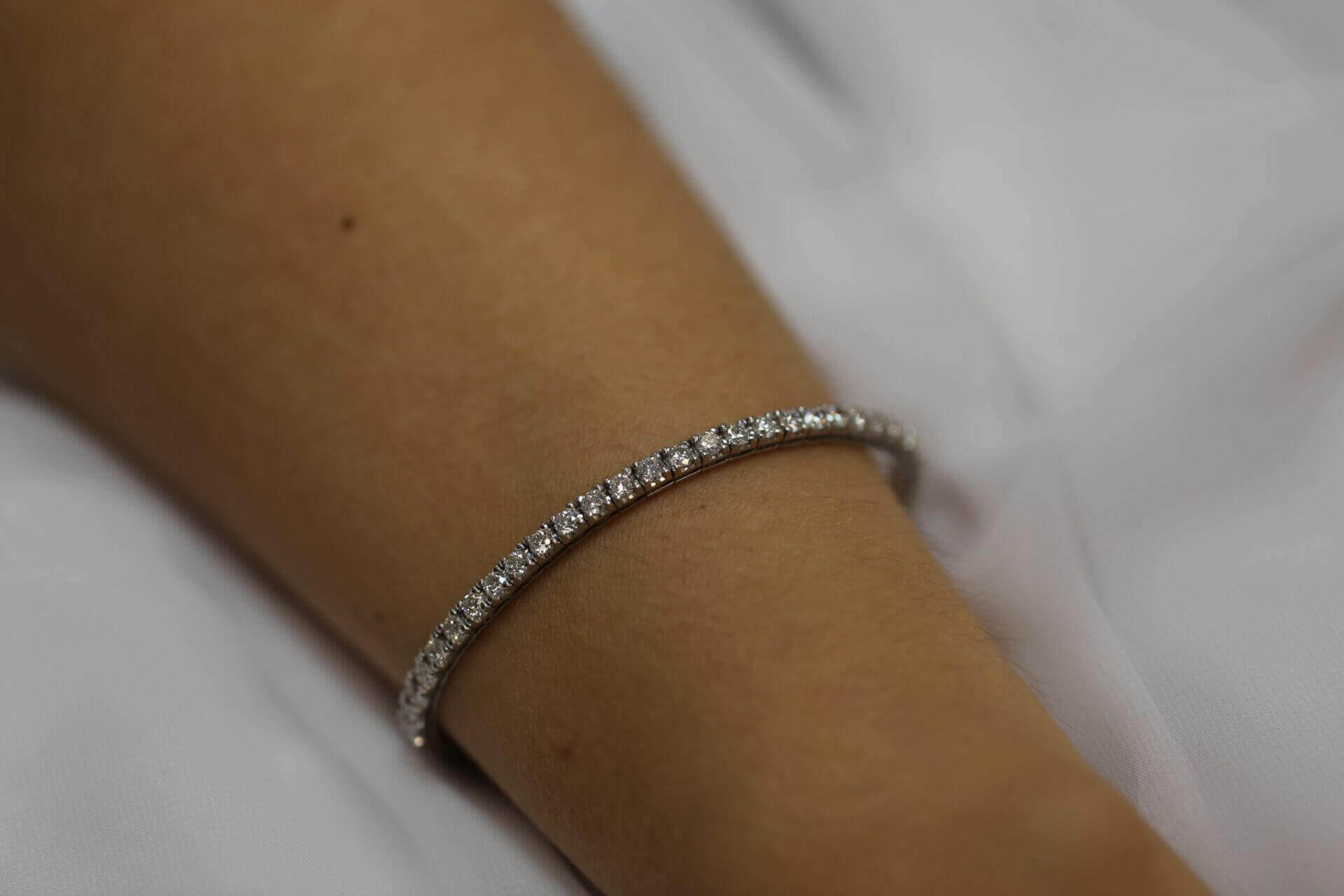A woman's wrist adorned with a beautiful claw set diamond tennis bracelet C926.