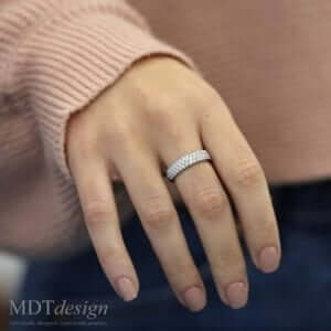 A woman's hand with a White Gold Half Round Pave Set Diamond Band C839 on it.