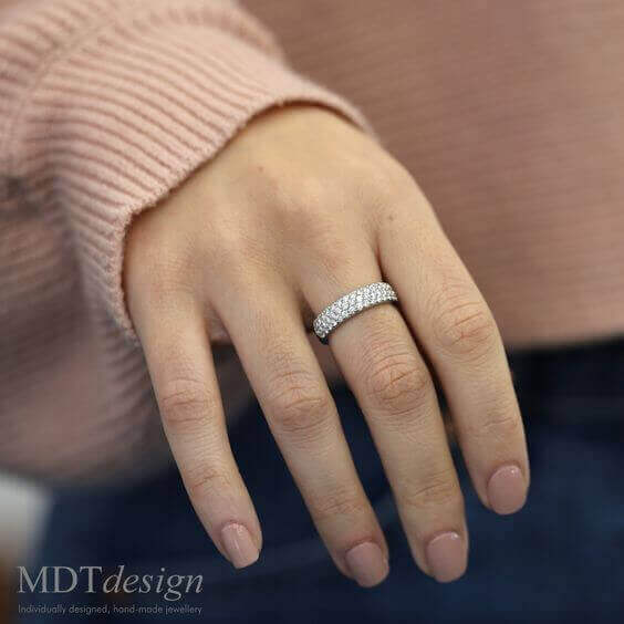 A woman's hand with a White Gold Half Round Pave Set Diamond Band C839 on it.