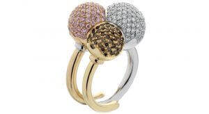 A unique award winning ring design "three wise men" featuring one rose gold with a pink diamond, yellow gold with champagne coloured diamonds the other white gold with a white diamond set-studded sphere.