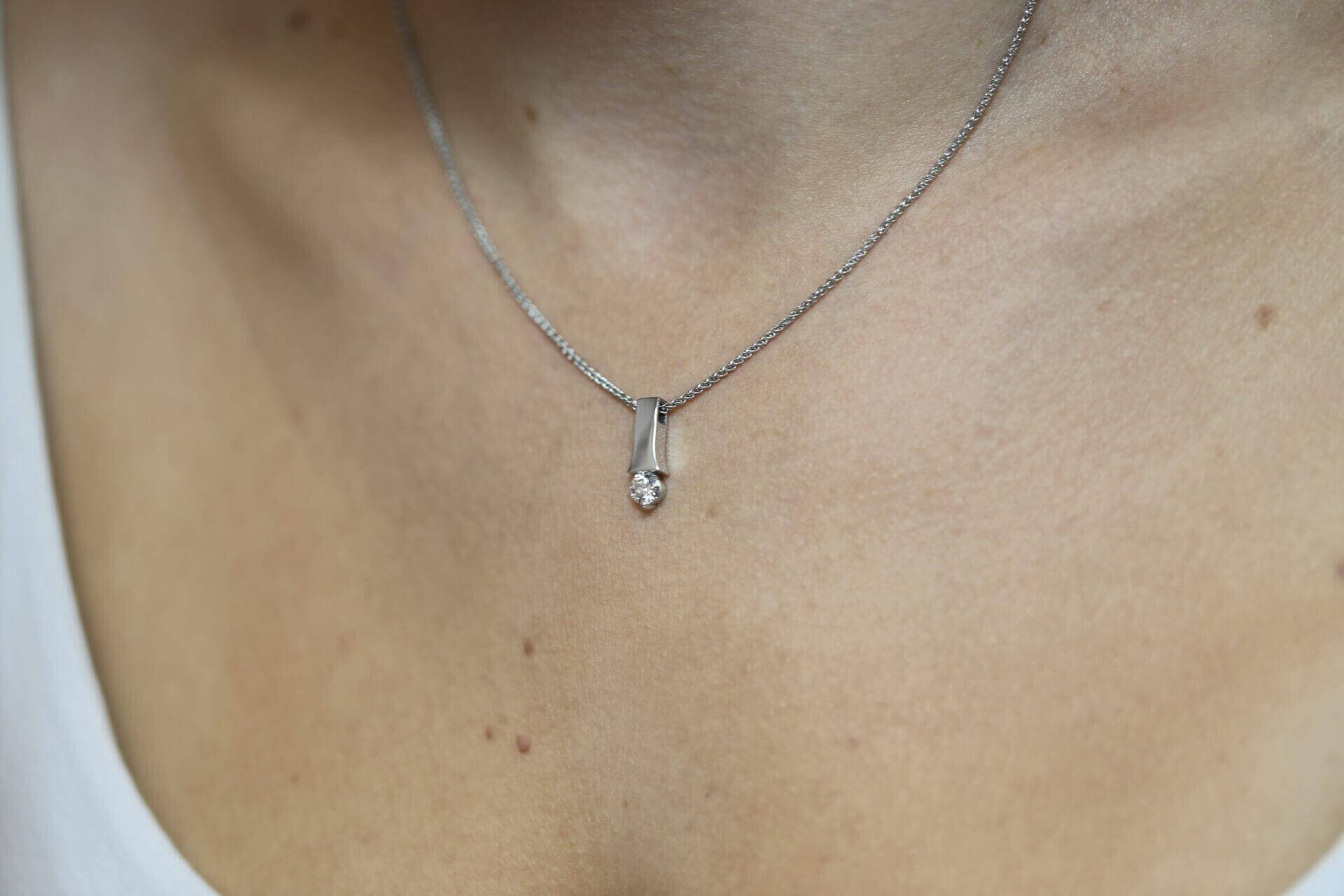 A close up of a woman's neck adorned with a brilliant Tension set diamond necklace C1006.