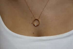 A woman is wearing a Tension set diamond necklace C1061-RG.