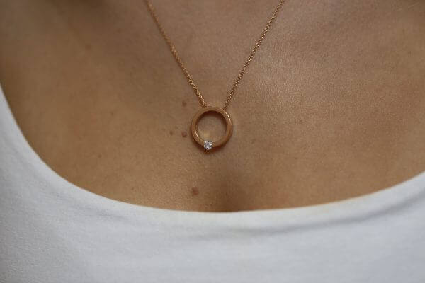 A woman is wearing a Tension set diamond necklace C1061-RG.