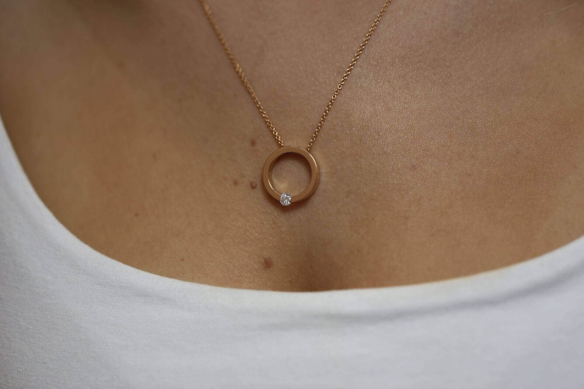 A woman is wearing a Tension set diamond necklace C1061-RG.