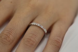 A woman's hand adorned with a stunning White and Pink Diamond Wedding Ring C573.
