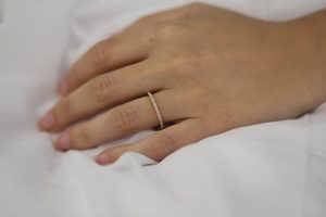 A woman's hand adorned with a Yellow gold claw set diamond wedding ring C571.