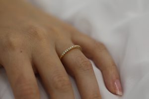 A woman's hand adorned with a Yellow gold claw set diamond wedding ring C571.
