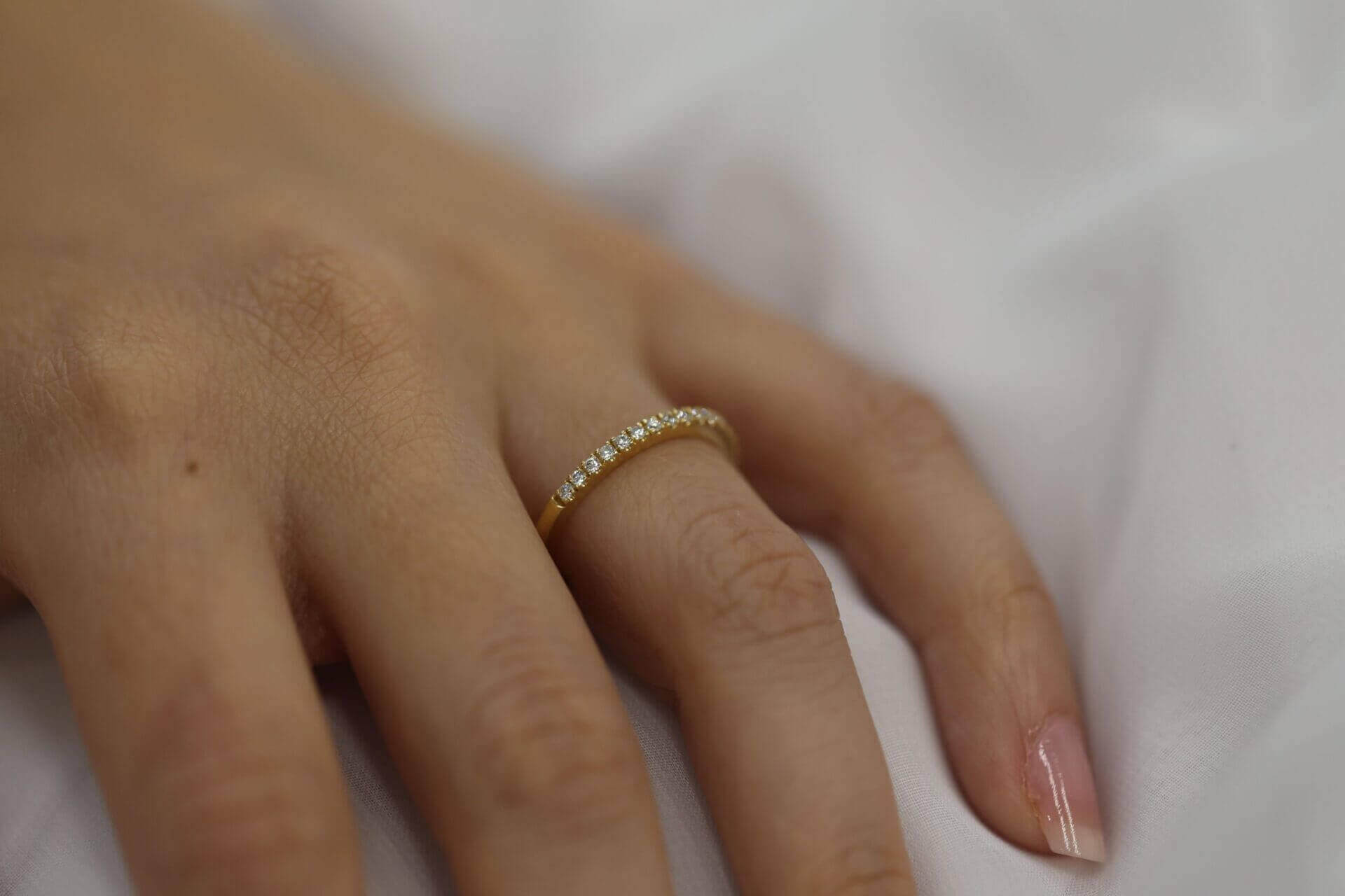 A woman's hand adorned with a Yellow gold claw set diamond wedding ring C571.