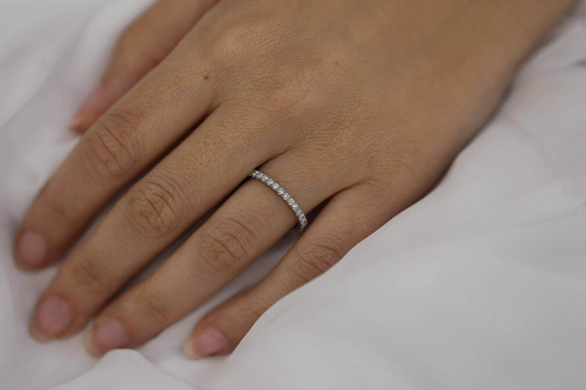 A woman's hand adorned with a White gold claw set diamond wedding ring C571.