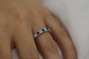 A woman's hand showcasing a stunning Claw set Ceylon sapphire wedding ring C577.