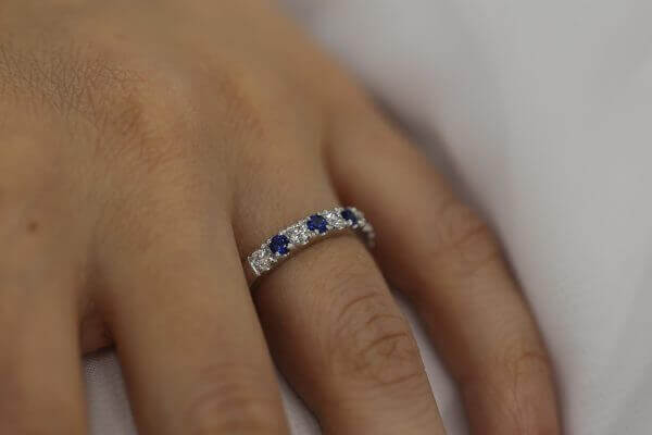 A woman's hand showcasing a stunning Claw set Ceylon sapphire wedding ring C577.