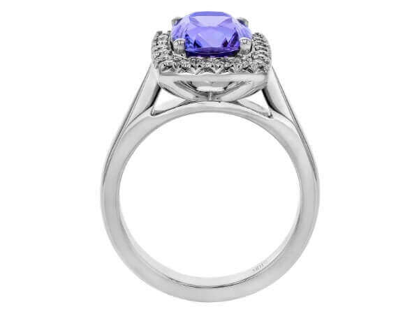 The Blue Tanzanite and Diamond Halo Engagement Ring C1067 features a stunning blue tanzanite surrounded by a diamond halo, all set in white gold.