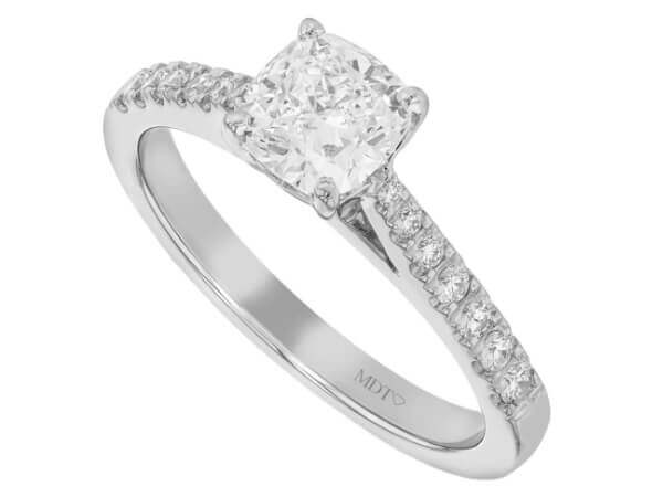A cushion cut diamond engagement ring in white gold with a diamond band.