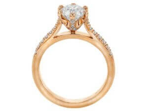 A stunning rose gold engagement ring with an oval cut diamond, featuring a hidden halo setting.