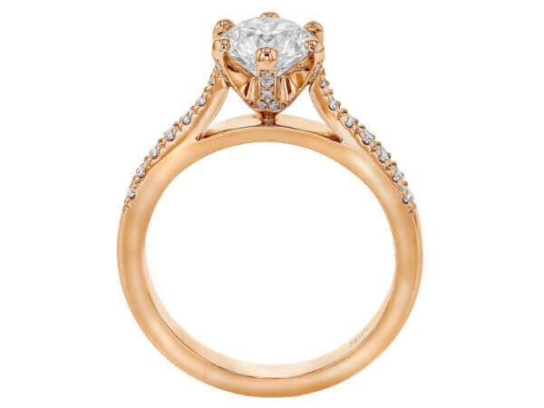 A stunning rose gold engagement ring with an oval cut diamond, featuring a hidden halo setting.