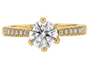 An oval diamond engagement ring in yellow gold with a hidden halo setting.