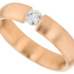 A tension set rose gold ring with a diamond in the center.
