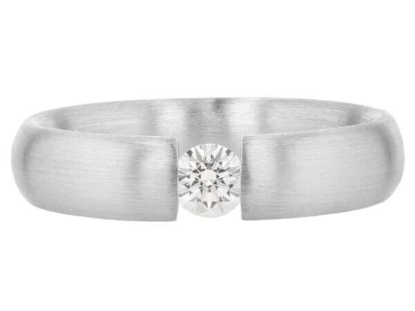 A white gold ring with a diamond tension set in the center.