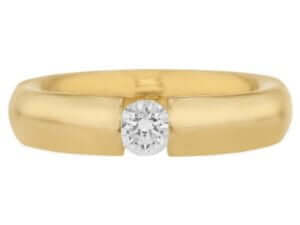 A tension set yellow gold ring with a diamond in the center with polished finish - top view