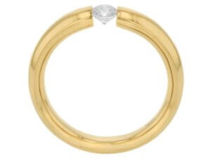A yellow gold polished ring with a diamond tension set in the center - side view