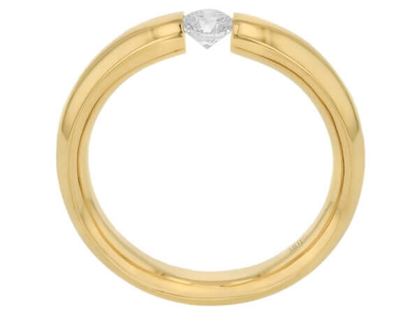 A yellow gold polished ring with a diamond tension set in the center - side view