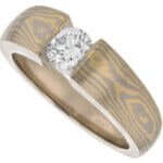 A Gold Diamond Mokume Gane Engagement Ring C1260 with a diamond in the center.