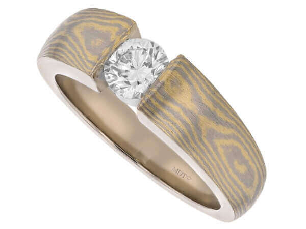 A Gold Diamond Mokume Gane Engagement Ring C1260 with a diamond in the center.