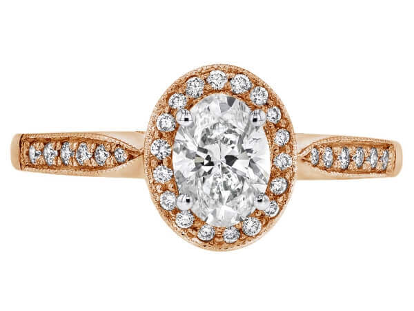 An oval diamond engagement ring in 18ct rose gold with small diamond halo.