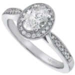 An oval diamond halo engagement ring in white gold featuring a grain set oval diamond.