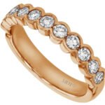A half bezel set round diamond wedding ring with a rose gold band.