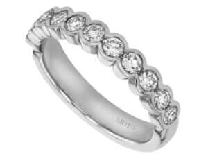 A half bezel set white gold band with round diamonds, perfect as a wedding ring.