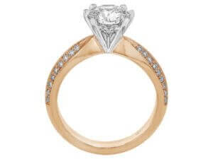 A diamond engagement ring with a round diamond in the center, delicately held by claw prongs, in a stunning rose gold setting.