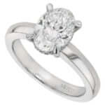 A white gold engagement ring with an oval cut diamond featuring a hidden halo.