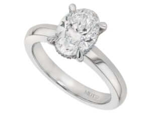 A white gold engagement ring with an oval cut diamond featuring a hidden halo.