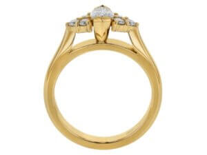 A marquise diamond trilogy engagement ring in yellow gold.