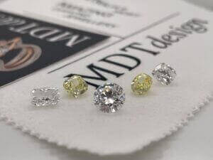 Assorted loose diamonds on branded paper.