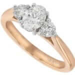 An elegant C380 three stone oval diamond trilogy engagement ring in rose gold.