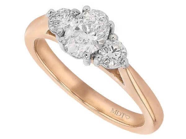 An elegant C380 three stone oval diamond trilogy engagement ring in rose gold.