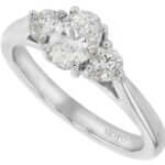 A trilogy engagement ring featuring an oval diamond set in 18ct white gold.