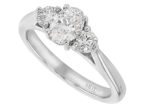 A trilogy engagement ring featuring an oval diamond set in 18ct white gold.