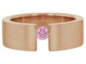 A tension set rose gold ring with a pink sapphire.