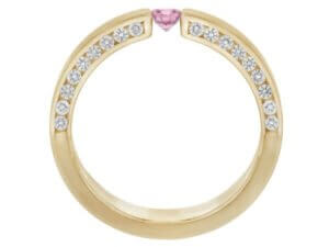 A pink sapphire and diamond tension set ring in yellow gold.