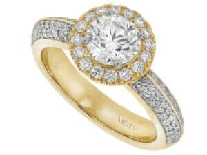 An exquisite engagement ring featuring a stunning round diamond halo elegantly set in yellow gold.